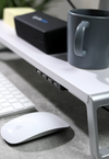 Βάση για οθόνη υπολογιστή από ξύλο σε λευκό χρώμα με μεταλλικά πόδια και θύρες φόρτισης USB.
